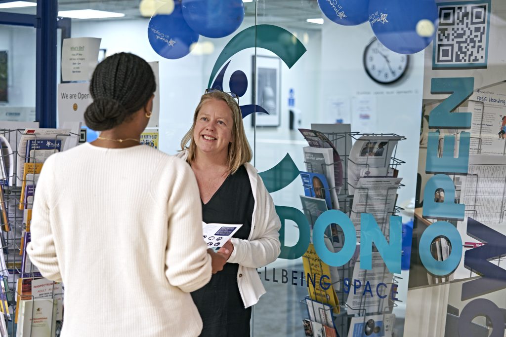 Two women standing and engaging in conversation