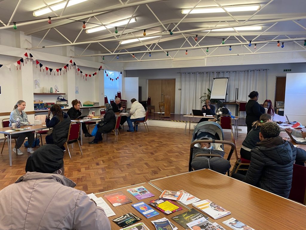 local residents gather in a church hall to talk to local support services
