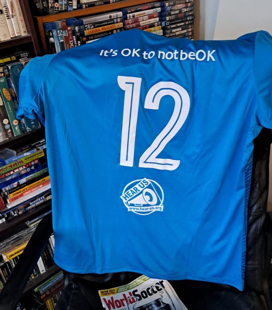 Football shirt with 'it's ok to not be ok' printed on the back
