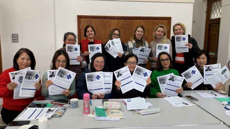12 ladies holding up leaflets