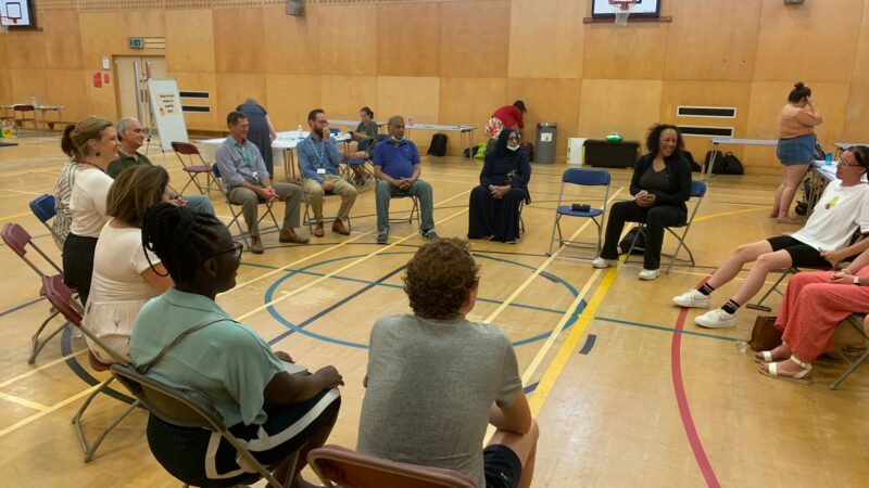 People sitting in a circle talking to health professionals about healthy living