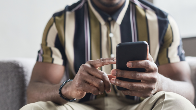 Seated male using smartphone