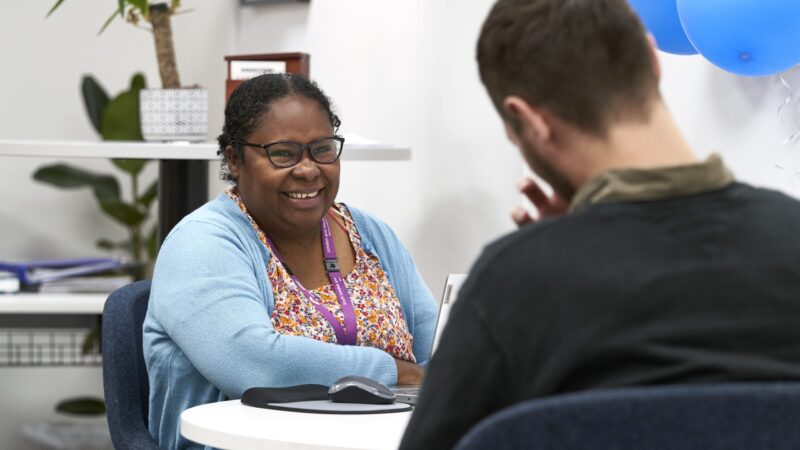 Woman sat at table smiling at male client